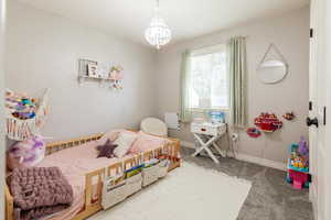 Bedroom featuring carpet and a chandelier