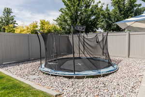 Fenced backyard with a trampoline