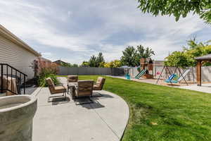 Fenced backyard with a playground and a patio