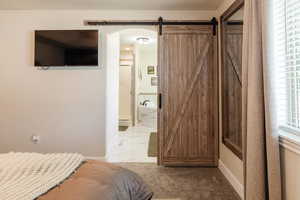 Bedroom with arched walkways, a barn door, and ensuite bath