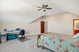 Bedroom featuring vaulted ceiling, carpet, a ceiling fan, a textured ceiling, and an office area