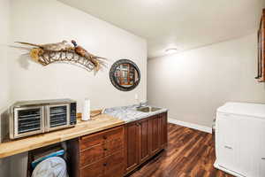 Bar featuring dark wood-style floors, independent washer and dryer, and a textured ceiling