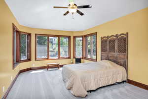 Carpeted bedroom featuring baseboards and a ceiling fan