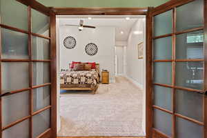 Carpeted bedroom with baseboards and french doors