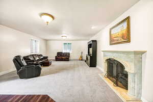 Living room with a high end fireplace and carpet floors