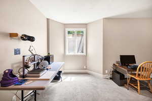 Carpeted office space with baseboards