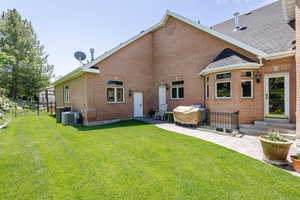 Back of house with a patio, brick siding, entry steps, and roof with shingles
