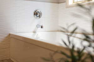 Full bathroom with tile walls