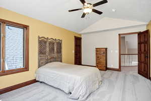 Bedroom with light carpet, lofted ceiling, and a ceiling fan