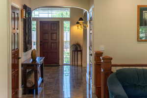 Entrance foyer with arched walkways and dark marble finish floors