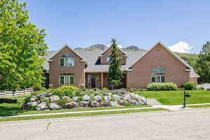 Traditional home featuring a front yard and brick siding
