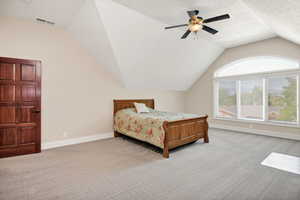 Bedroom featuring light colored carpet, lofted ceiling, and ceiling fan