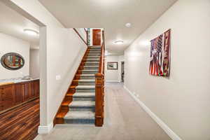 Stairs with a textured ceiling and carpet floors