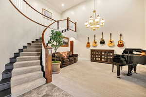 Stairs featuring a towering ceiling, arched walkways, and a chandelier