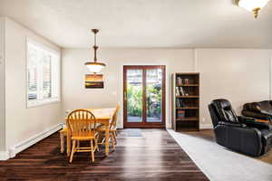Dining area featuring a baseboard heating unit and dark wood-type flooring