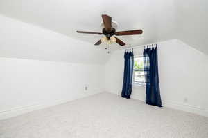 Bonus room with vaulted ceiling, carpet, and ceiling fan