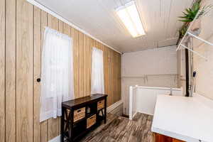 Laundry area with wood finished floors, wooden walls, and wood ceiling