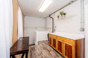 Washroom with wood finished floors and brick wall