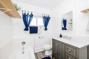 Bathroom featuring a garden tub, vanity, and wood finished floors