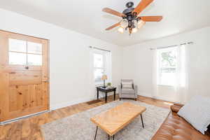 Living area with ceiling fan and wood finished floors