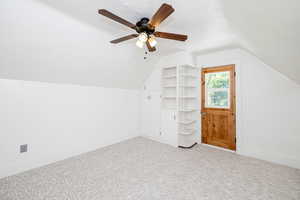 Bonus room with lofted ceiling, carpet flooring, and a ceiling fan