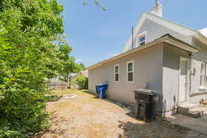 View of home's exterior featuring entry steps, a chimney, and a metal roof
