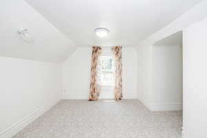 Bonus room with carpet flooring and lofted ceiling