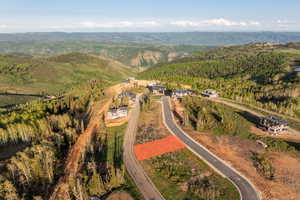 Aerial view of property and surrounding area with a mountain backdrop