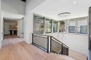 Hallway with wood-type flooring and recessed lighting