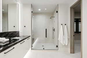 Full bath featuring vanity, a shower stall, recessed lighting, a walk in closet, and tile patterned flooring