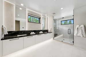 Full bath featuring double vanity, a shower stall, and recessed lighting