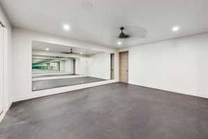 Garage with a ceiling fan and recessed lighting