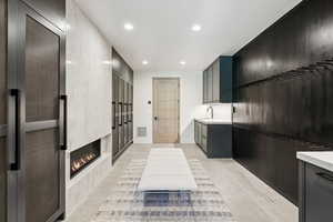 Kitchen with light countertops, recessed lighting, light tile patterned flooring, a heating unit, and a fireplace