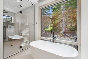 Bathroom featuring a shower stall, tile patterned flooring, and plenty of natural light