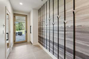 Doorway with light tile patterned floors and recessed lighting