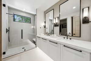 Bathroom with double vanity and a stall shower