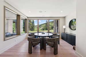 Dining room with light wood-type flooring and recessed lighting