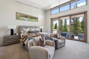 Carpeted bedroom with access to exterior, recessed lighting, and a towering ceiling