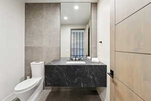Bathroom with vanity, tile walls, and recessed lighting