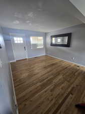 Foyer with dark wood finished floors and baseboards