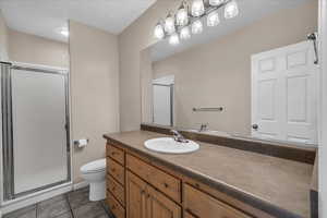 Bathroom featuring a stall shower, tile patterned flooring, and vanity