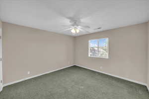 Empty room with a ceiling fan and carpet floors