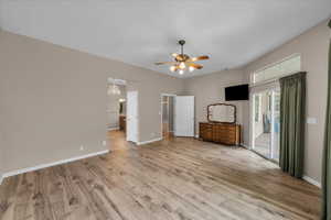 Unfurnished living room with a chandelier, ceiling fan, and light wood finished floors