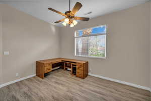 Unfurnished office featuring light wood-style flooring and a ceiling fan