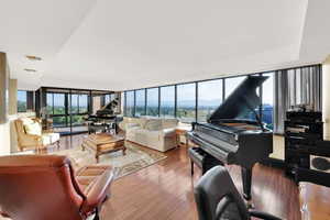 Living area with wood finished floors and floor to ceiling windows