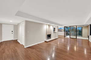 Unfurnished living room featuring a glass covered fireplace, light wood-style flooring, and recessed lighting