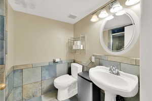 Bathroom with tile walls and a wainscoted wall