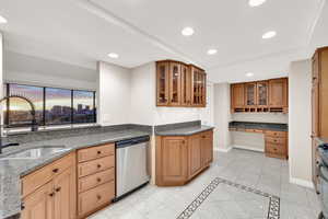 Kitchen featuring recessed lighting, appliances with stainless steel finishes, dark stone countertops, glass insert cabinets, and light tile patterned floors