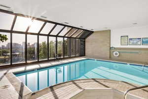 View of indoor pool with outside sun area