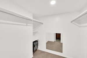 Spacious closet with light colored carpet